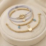 Set brățări 4 în 1 pentru picior cu șnur gri, mărgele aurii și pandantive delicate, Naiara®