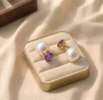 Cercei placați cu aur de 14K, tribali cu două fețe, cu cristal violet fațetat și perlă mare albă, Noem®