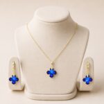 Set placat cu aur de 14K compus din lănțișor cu pandantiv și cercei, model elegant cu cristale în formă de cruce/floare stilizată de un albastru-safir intens, 41+5 cm / 33/13 mm, Noem®