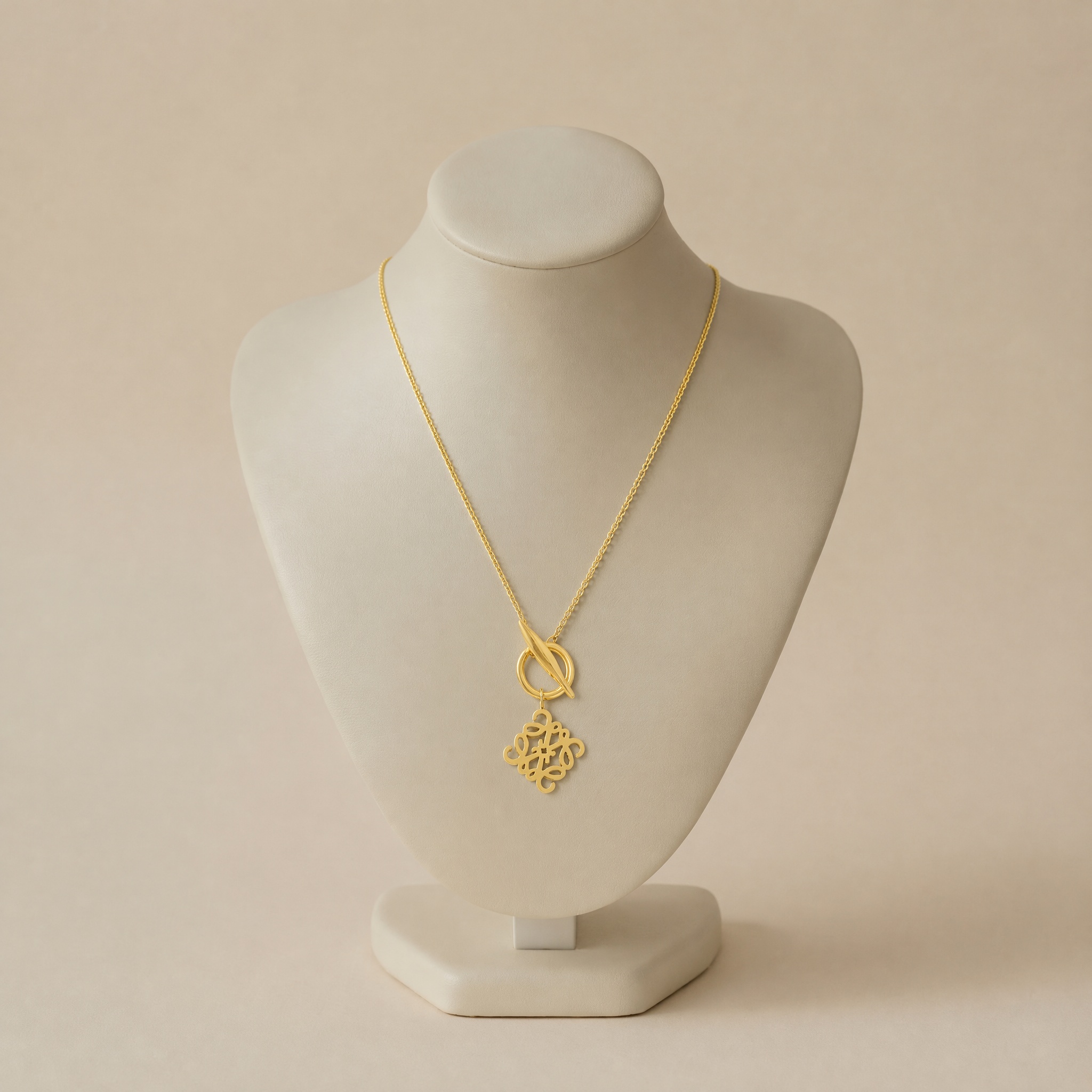colier_noem_pe_bust_2x2cm_2 Colier statement din oțel inoxidabil aurit, design abstract cu emblemă geometrică stilizată și prindere în față, lungime 53 cm, fără pietre, Noem® - imagine 1