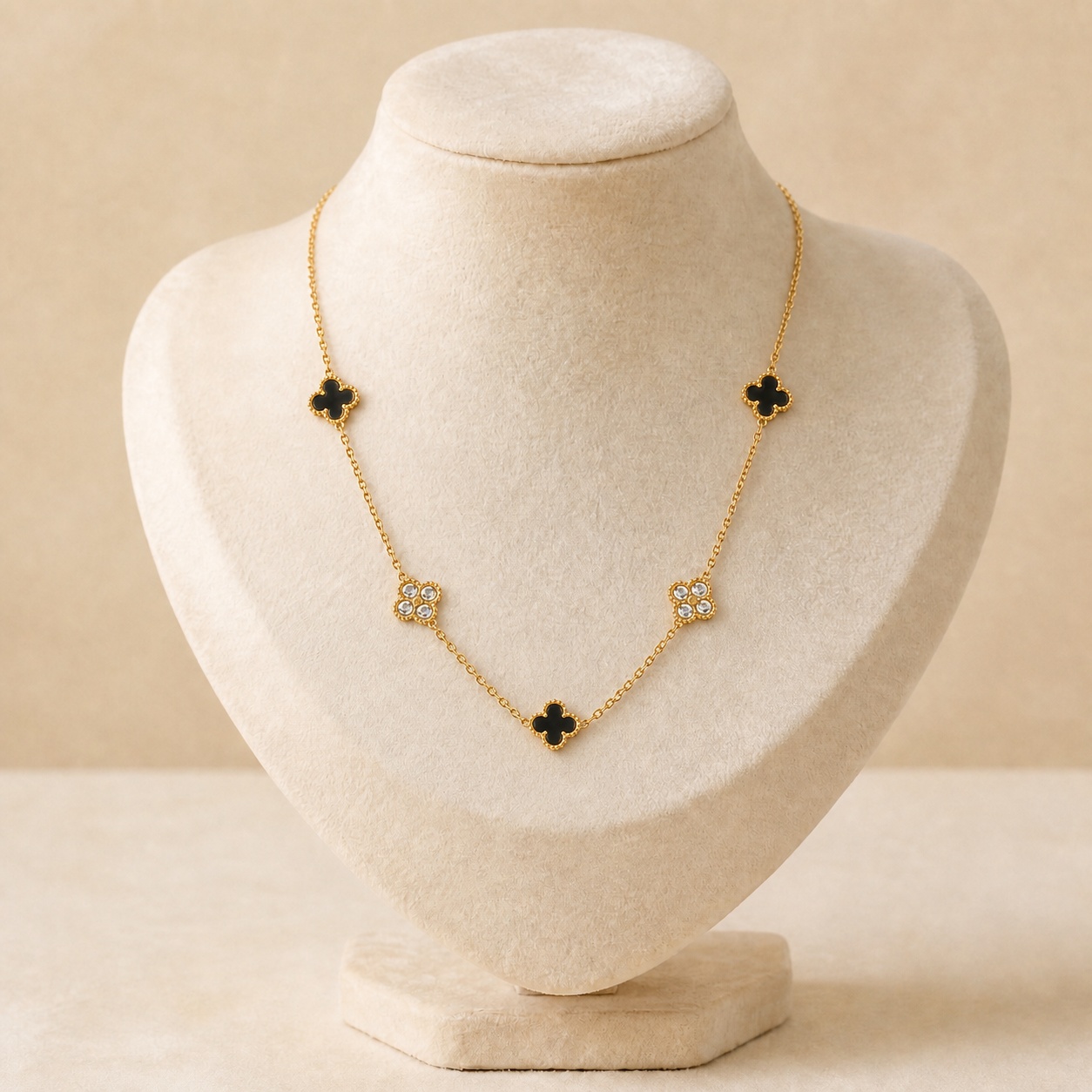 colier_trifoi_pe_bust_noem_2 Colier elegant din oțel chirurgical placat cu aur de 14K, lungime 41+5 cm, decorat cu motive trifoi norocos de culoare neagră alternând fin cu trifoi placați cu cristale strălucitoare din zirconiu cubic, Noem® - imagine 1
