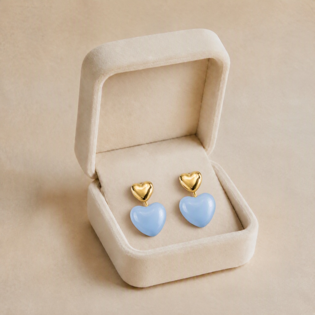 noem_cercei_inimi_bleu_in_cutie Cercei statement din oțel inoxidabil placat cu aur de 14K, model semne de inimă în două tonuri cu email lucios albastru cer și element bombat auriu, prindere cu șurub, 2,8 cm, Noem® - imagine 1